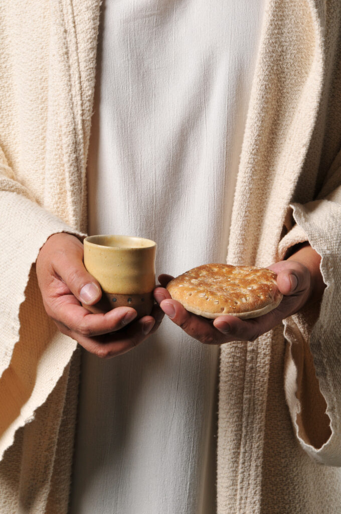 Jesus holding a bread and a wine as a symbol of communion.