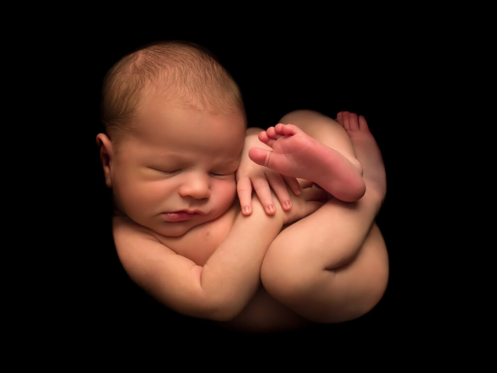 A newborn baby sleeping in the fetal position.