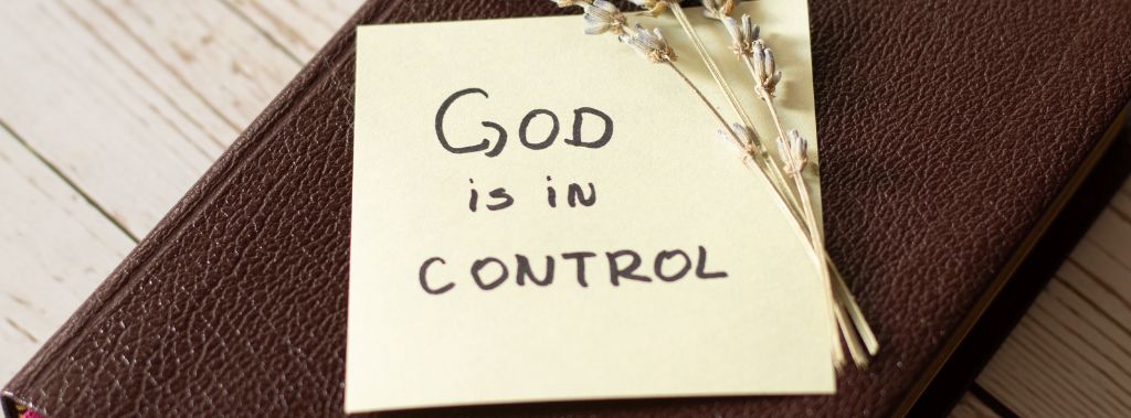 Bible with handwritten note on it that says "God is in control."