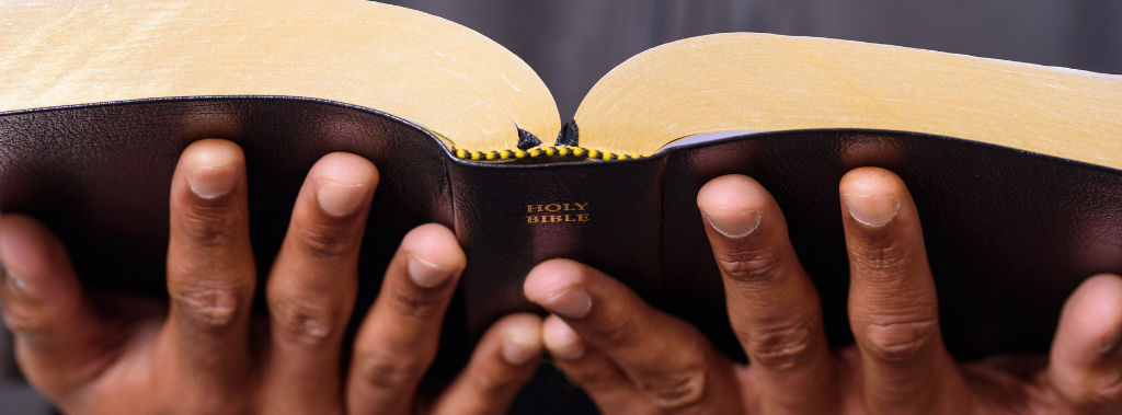 A close up view of a man hands holding the Holy Bible
