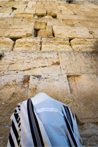 Orthodox Jew wearing a tallit cloak as he prays at the Western Wall.