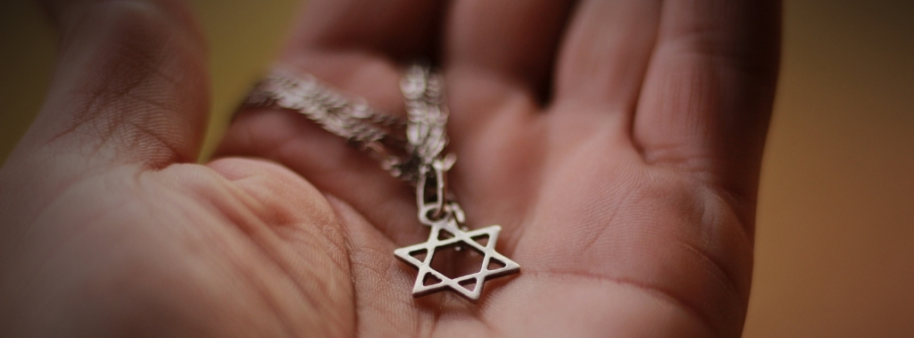 Star of David necklace resting in the palm of a hand.