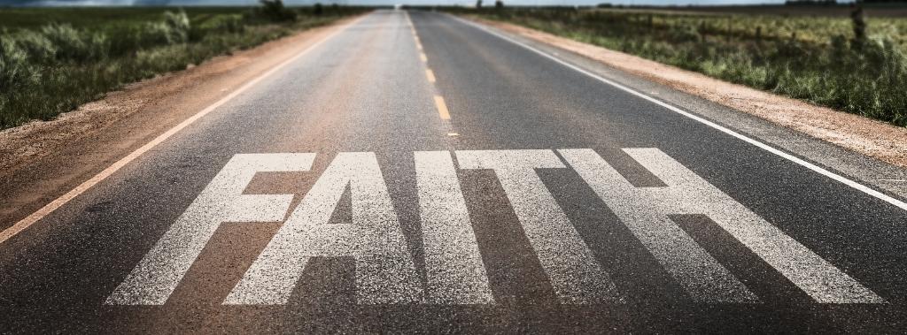The word "Faith" painted on a remote road.