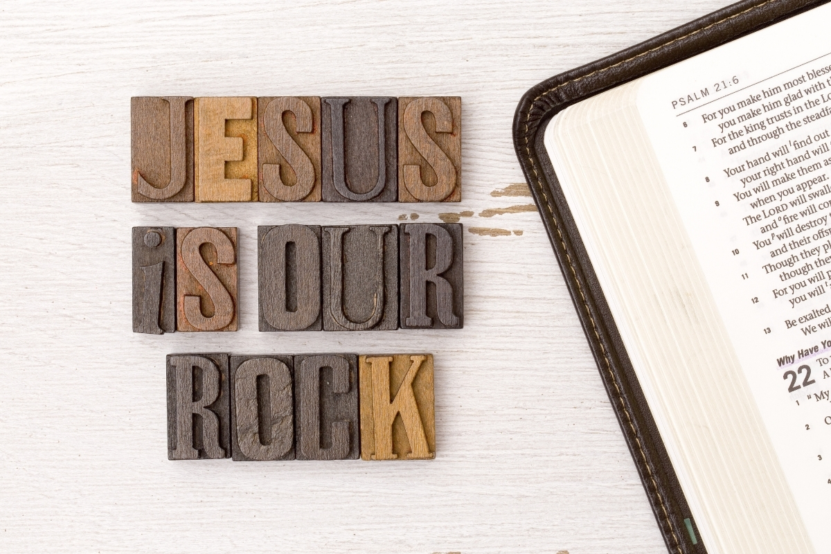 The words "Jesus is our rock" in block letters next to leather Bible.
