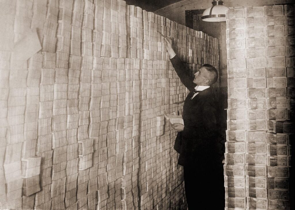 Banker in suit counting stacks of German marks.