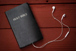 Contemporary image of a Bible with headphones. Hearing the voice of God concept.