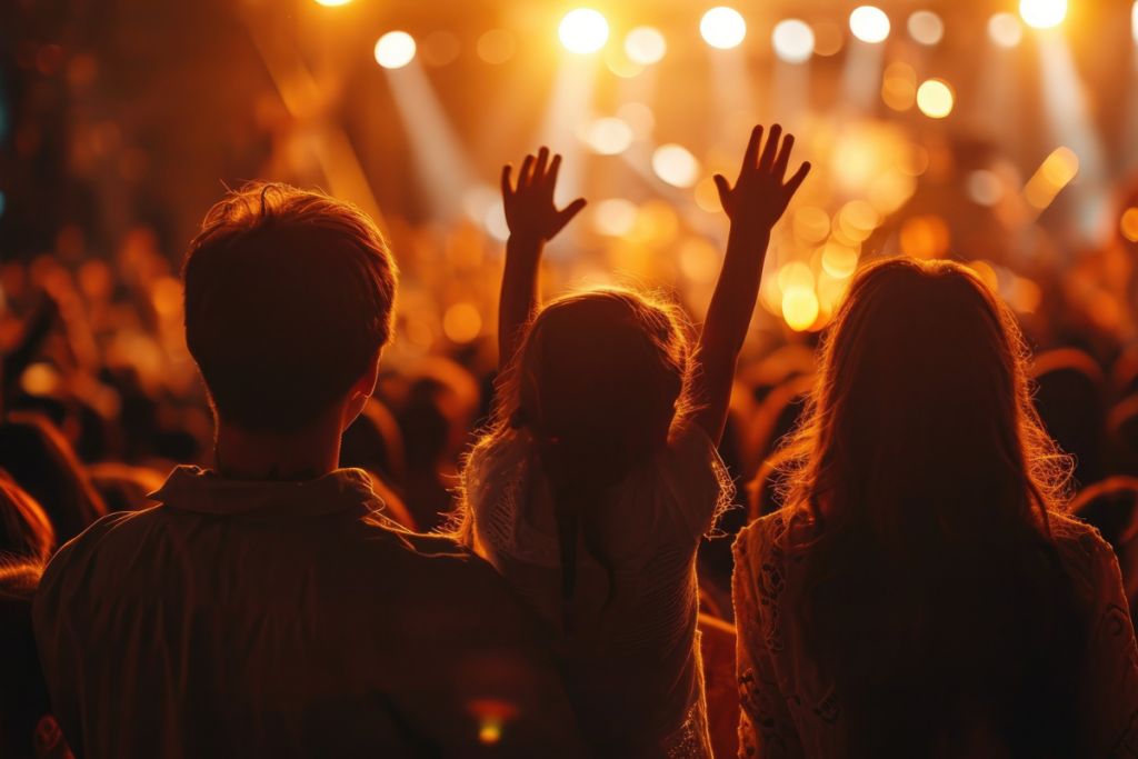 Family with young daughter raising her hands in church to worship. 
